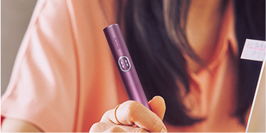 Hand holding an IQOS ILUMA i PRIME holder.