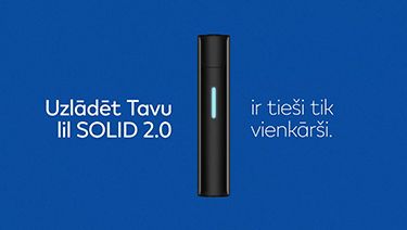 Stone Grey lil SOLID 2.0 ierīce ar spīdošu uzlādes LED gaismu uz zila fona